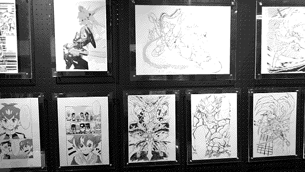 A closeup of the gallery wall focusing on pages from Hideaki Fujii's other works.