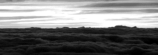 A landscape of darkened clouds lit up by the setting sun.